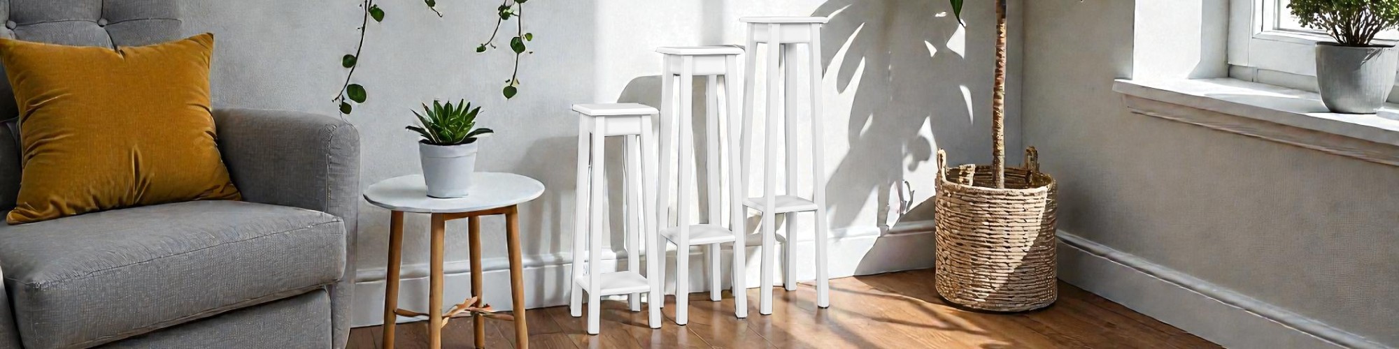 Tris di colonne portapiante bianche di diverse altezze, ideali per decorare angoli living luminosi